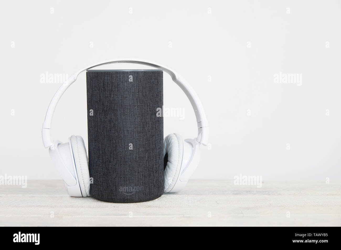 Smart dispositivo altoparlante e hearphones sulla sinistra contro uno sfondo bianco. Svuotare lo spazio di copia per l'editor di testo Foto Stock