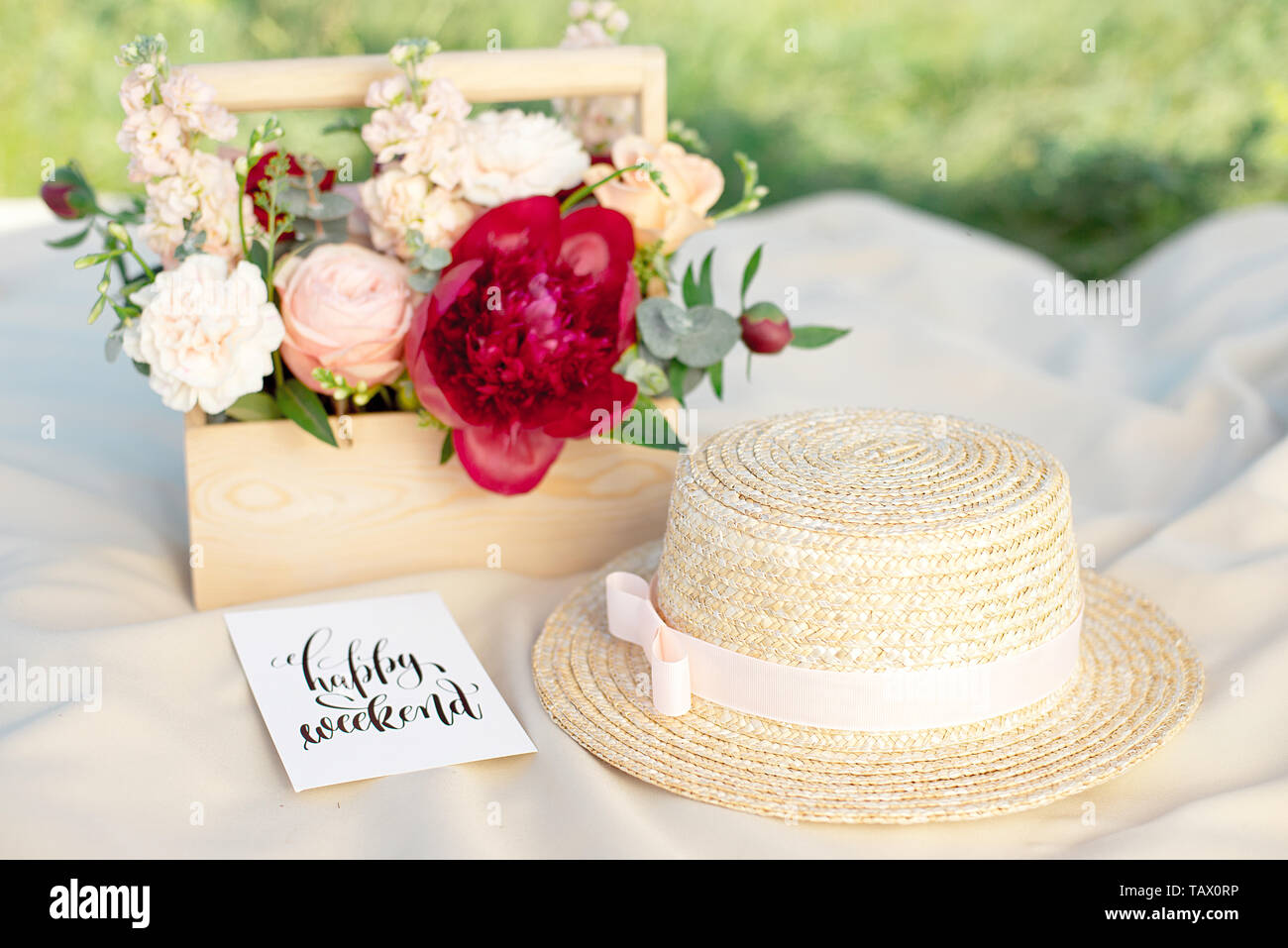 Cappelli di paglia giaceva su un bianco Coperta picnic a prato verde luminoso giorno d'estate. Foto Stock