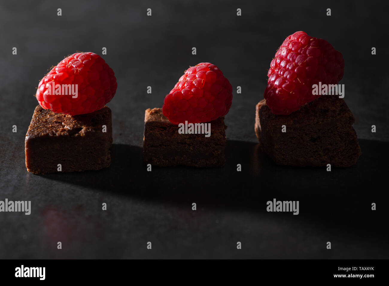 Brownie al cioccolato con topping di lampone. Bassa illuminazione tasto Foto Stock