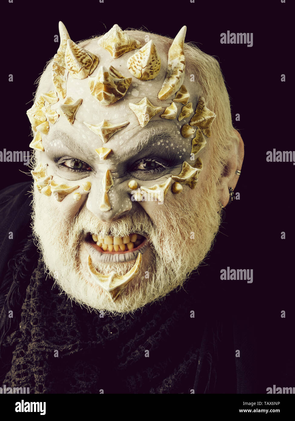 Angry monster uomo a denti stretti con il bianco degli occhi e barbuto spinoso faccia su sfondo nero. L' orrore e la nozione di fantasia. Foto Stock