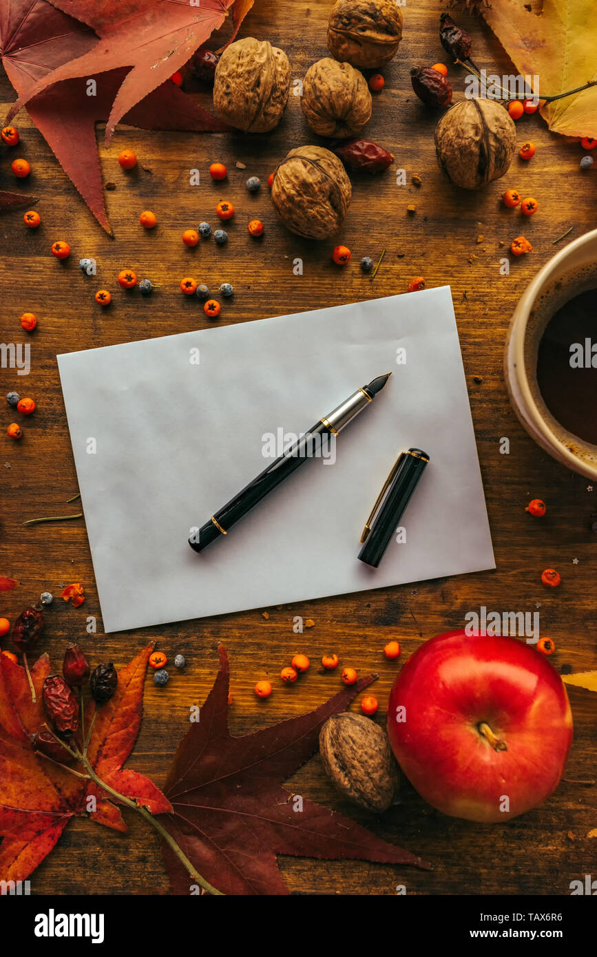 Autunno busta posta flat lay mock up sul tavolo in legno decorato a secco con foglie di acero e frutta di stagione Foto Stock