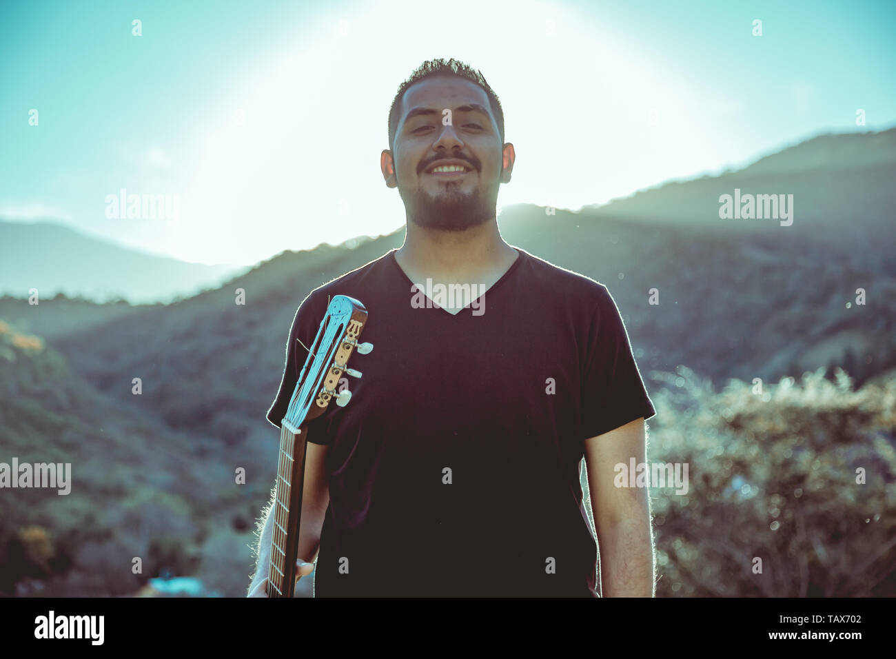 Uomo a suonare la chitarra sulle montagne Foto Stock