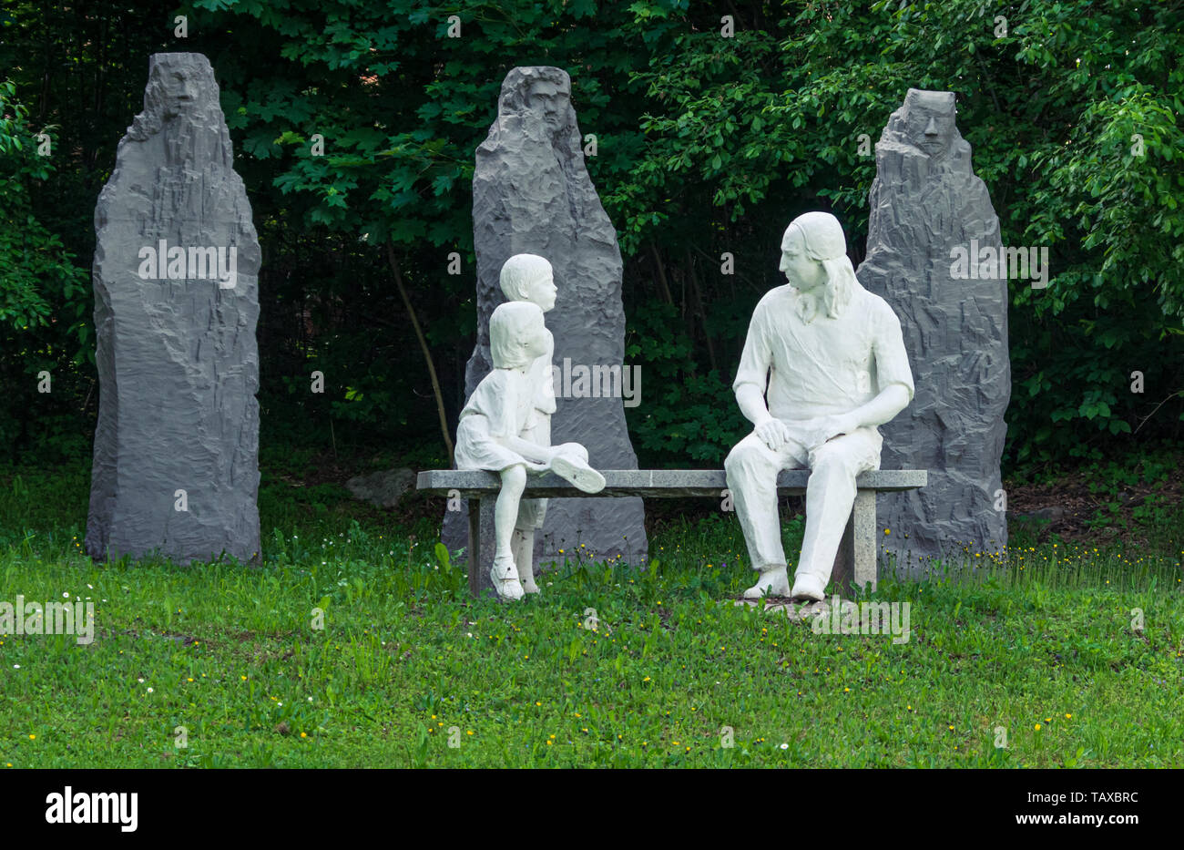 Statua di Nikolaus Ludwig, Reichsgraf von Zinzendorf und Pottendorf insegnamento a bambini seduti su una panchina di pietra in un parco. Foto Stock