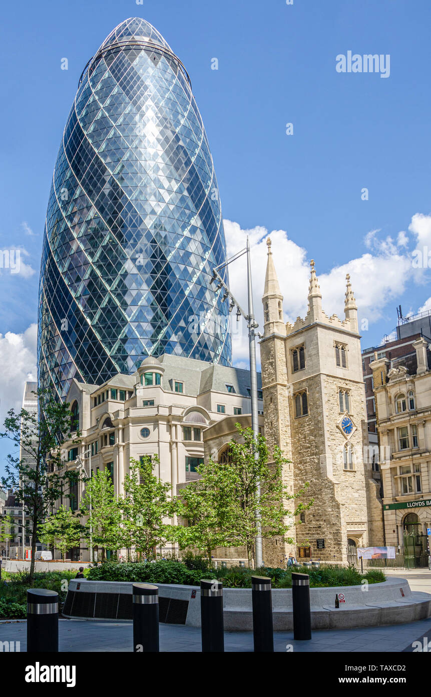 30 St Mary Axe altrimenti noto come il Gherkin visto dietro St Andrew Undershaft chiesa nel quartiere finanziario della City di Londra. Foto Stock