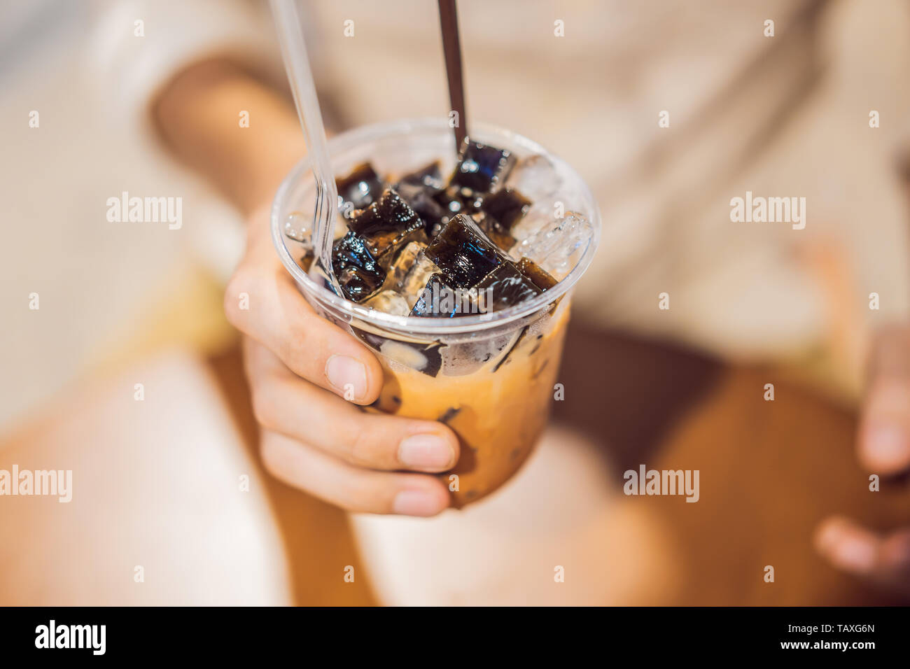 Uomo di bere freddo tè bolla in cafe Foto Stock