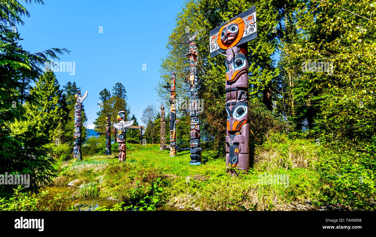 Indigeni coloratissimi Totem Rappresentare arte e simboli religiosi della West Coast i popoli indigeni collocati in Stanley Park a Vancouver in Canada Foto Stock