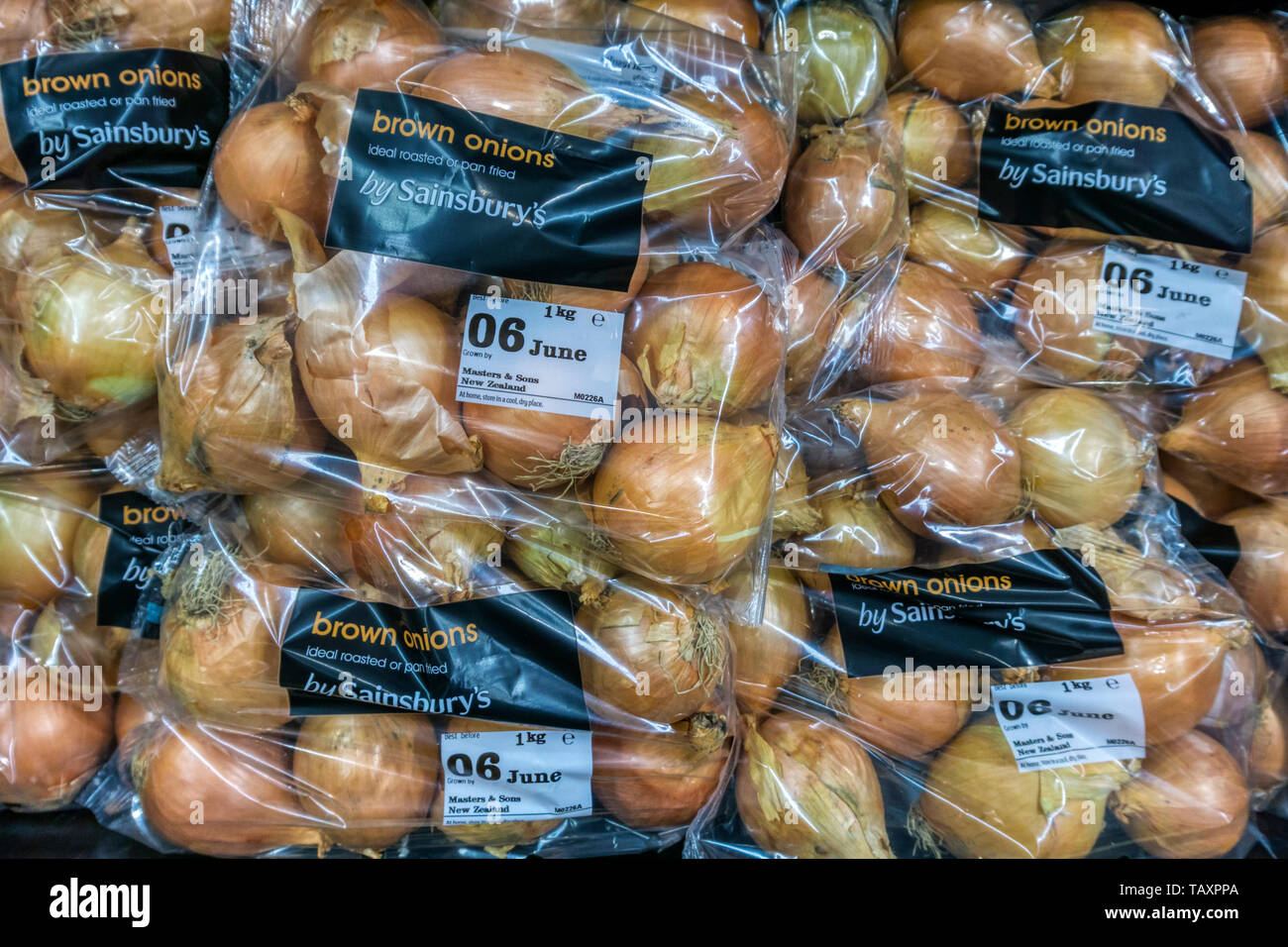 Sacchetti di plastica di Nuova Zelanda rosolare le cipolle per la vendita in un Sainsbury's supermercato. Foto Stock