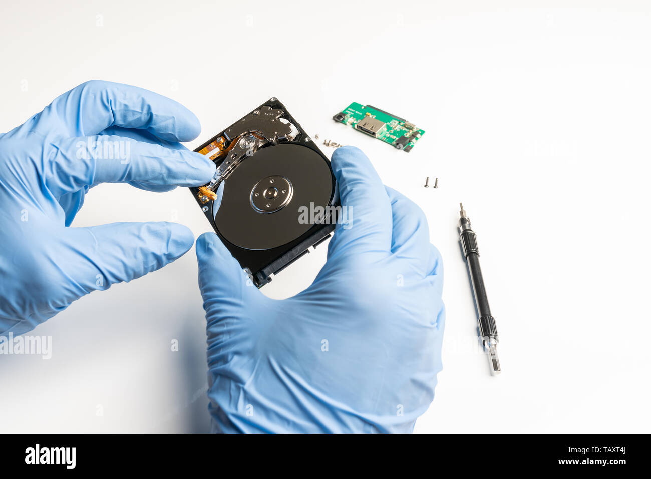 Ispezione visiva di un aperto hard disk con i guanti Foto Stock