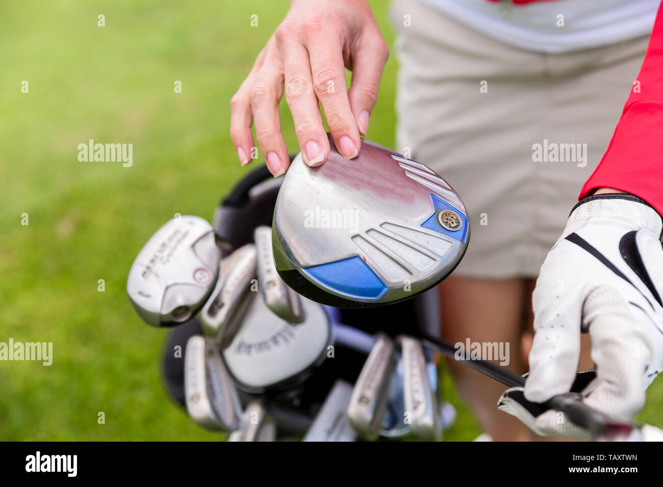 Close-up di giocatrice scegliendo golf club Foto Stock