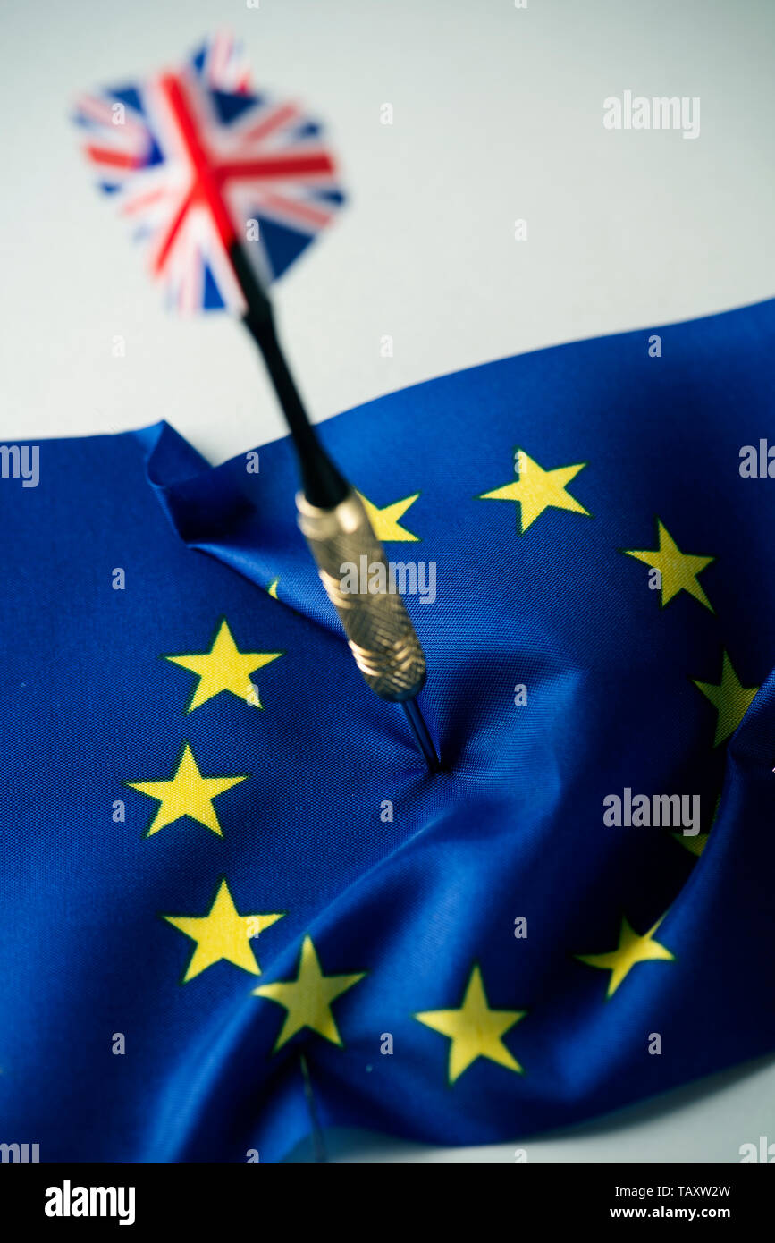 Primo piano di un dardo modellato con la bandiera del Regno Unito bloccati nel mezzo di una bandiera dell'Unione europea Foto Stock