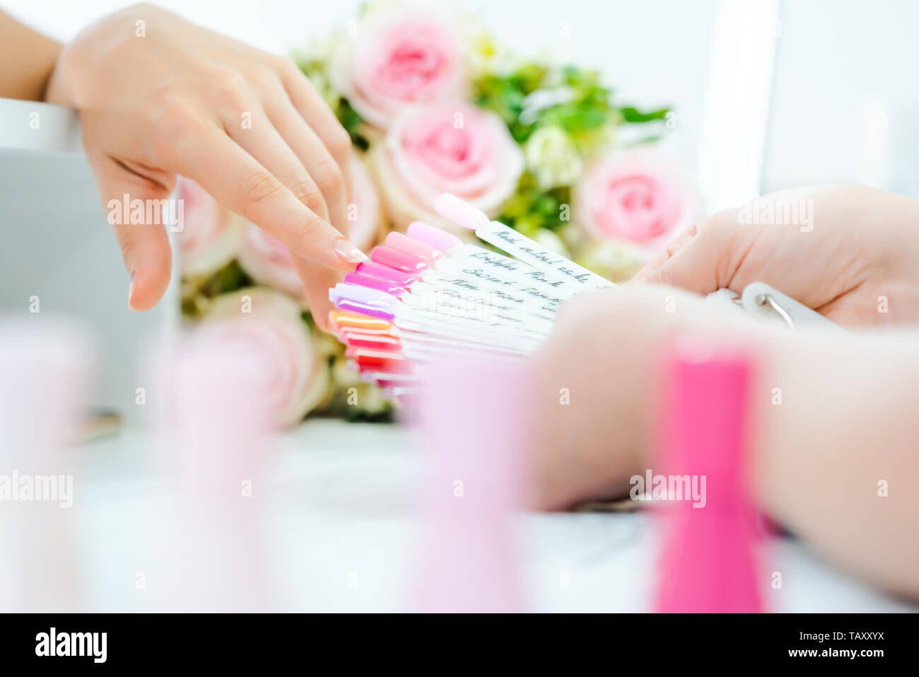 La donna durante il manicure scegliendo un colore per unghie Foto Stock