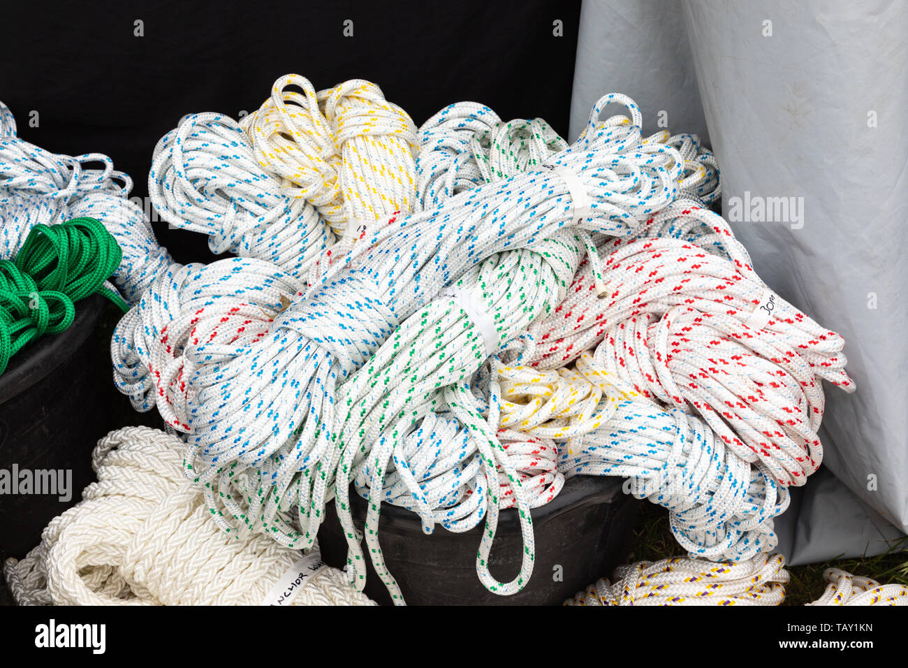 Crick, Northamptonshire, Regno Unito: Matasse di corda di nylon bianco con macchie colorate piazzate in modo casuale in una benna nera. Foto Stock