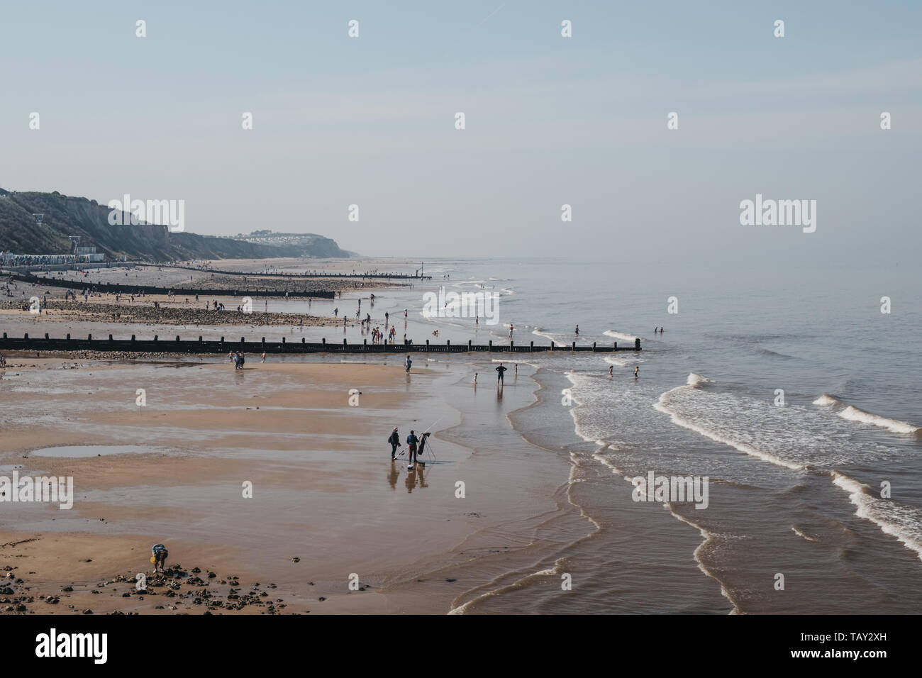 Cromer, Regno Unito - 20 Aprile 2019: le persone che si godono la giornata di sole su una spiaggia a Cromer, una cittadina balneare nel Norfolk e una famiglia popolare meta di vacanza nel Regno Unito. Foto Stock
