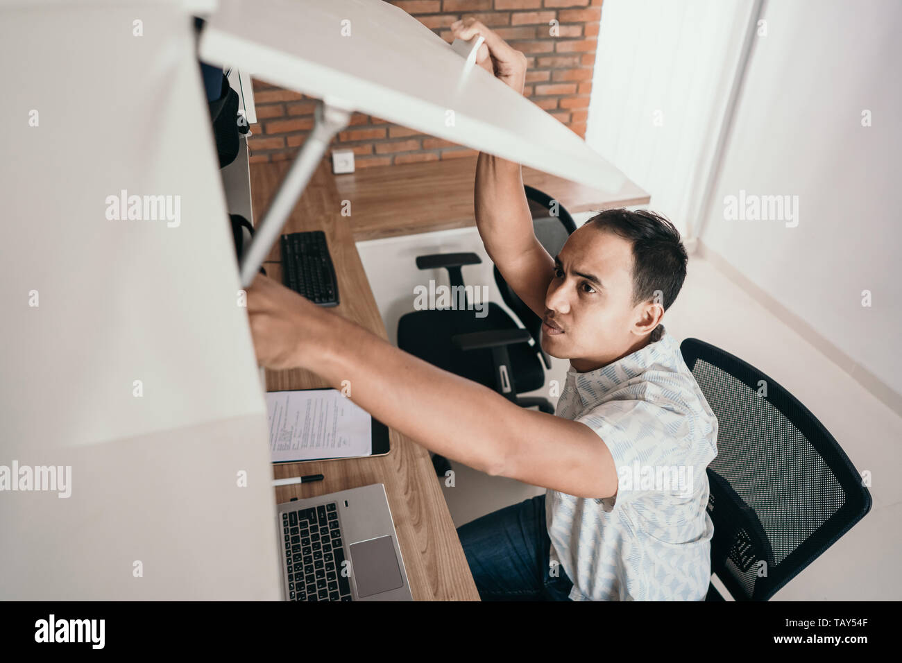 I lavoratori di sesso maschile aprire il cassetto superiore per prelevare i file Foto Stock