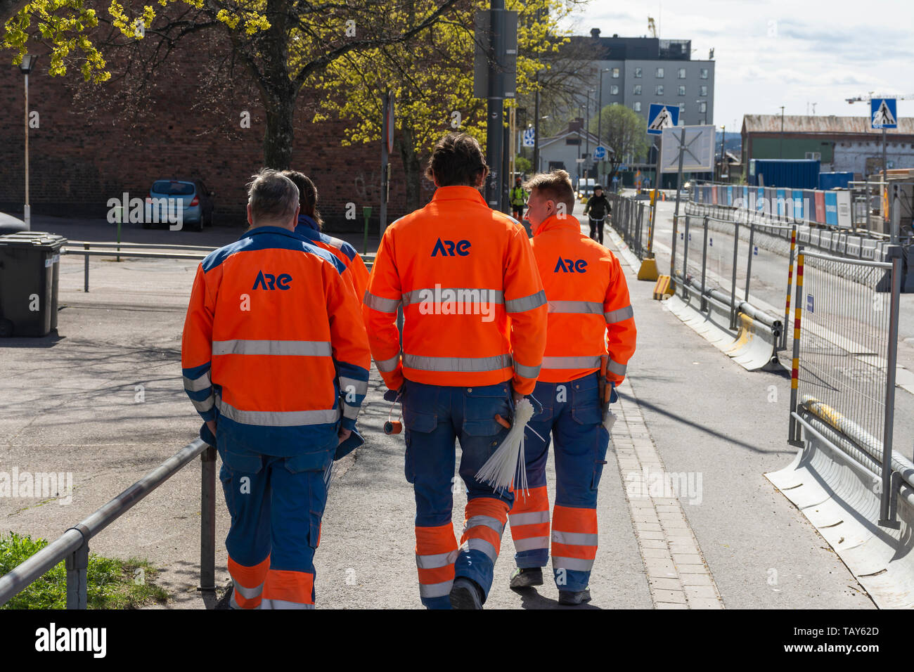 Tre lavoratori che camminano per la strada a Tampere, Finlandia Foto Stock