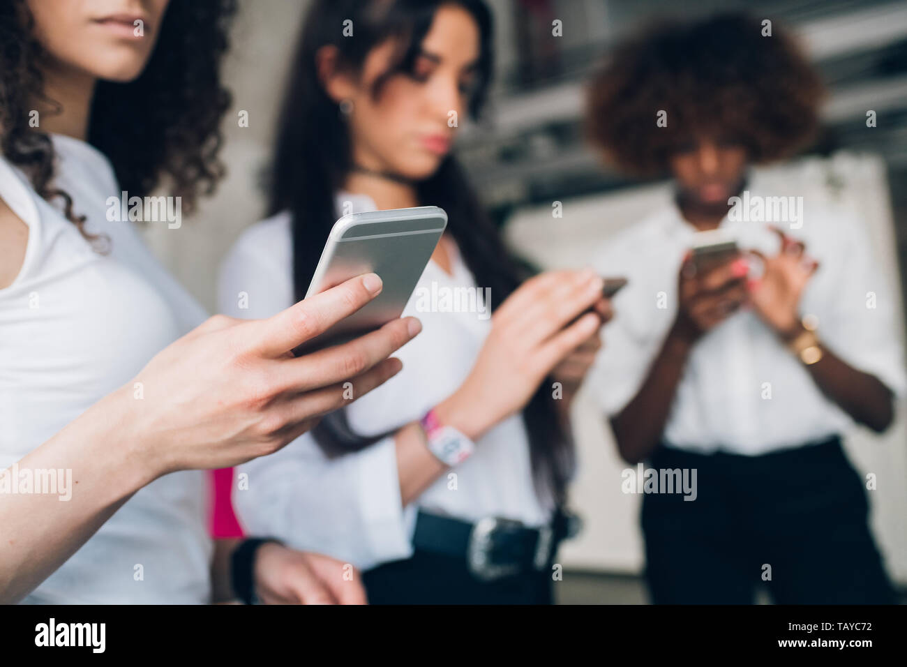 Tre giovani imprenditrici che interagiscono e la condivisione dei dati con smartphone - tecnologia, Comunicazione, freelance Foto Stock