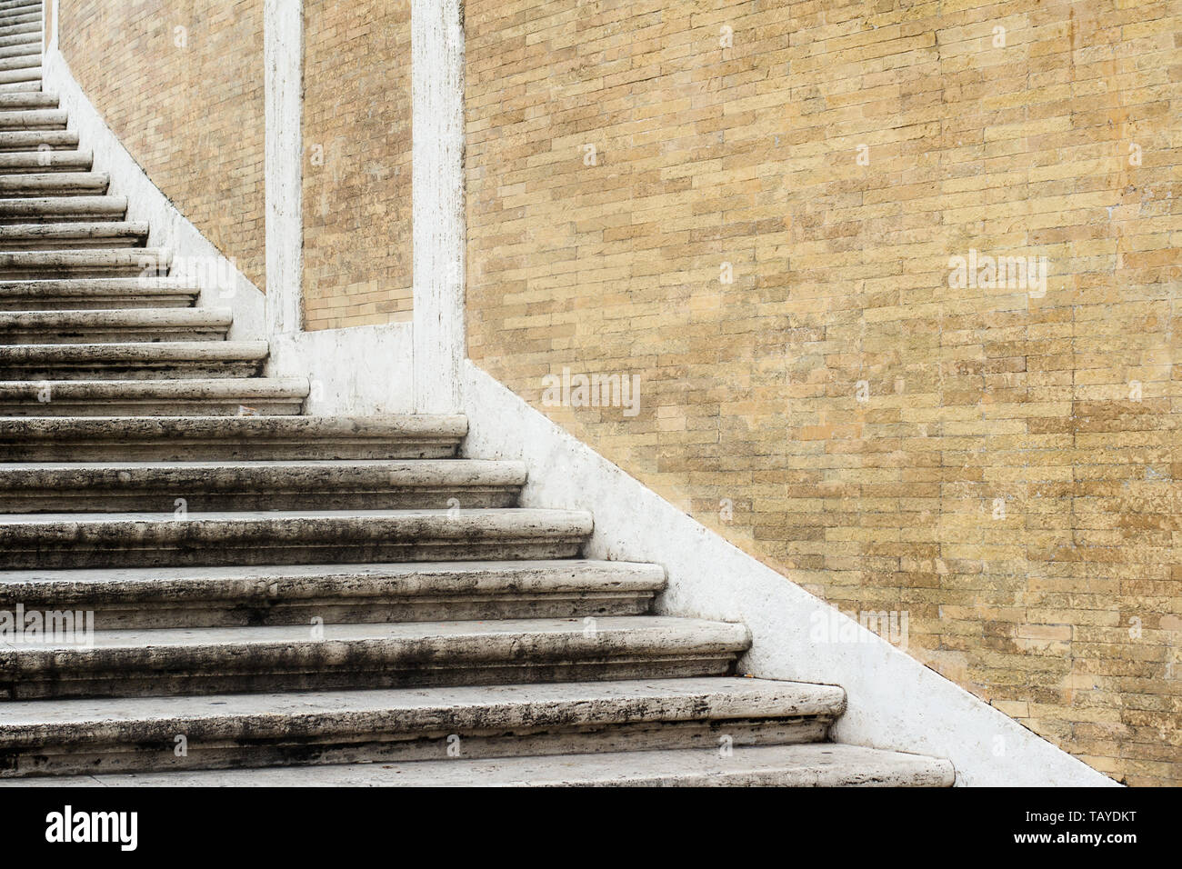 Vista prospettica closeup modello di ampia pietra classica a spirale scale in prossimità di una luce marrone muro di mattoni copyspace disponibile Foto Stock