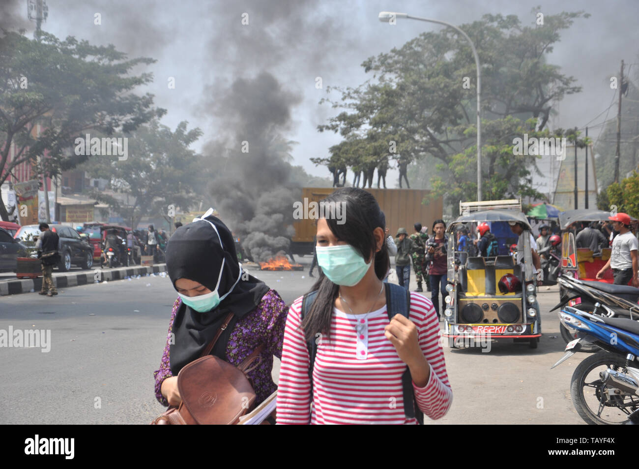 Ragazze indonesiane a piedi vicino agli studenti rally di fronte Muhammadiah University a Allaudin Street. Gli studenti universitari in tutta l'Indonesia tenere street ra Foto Stock