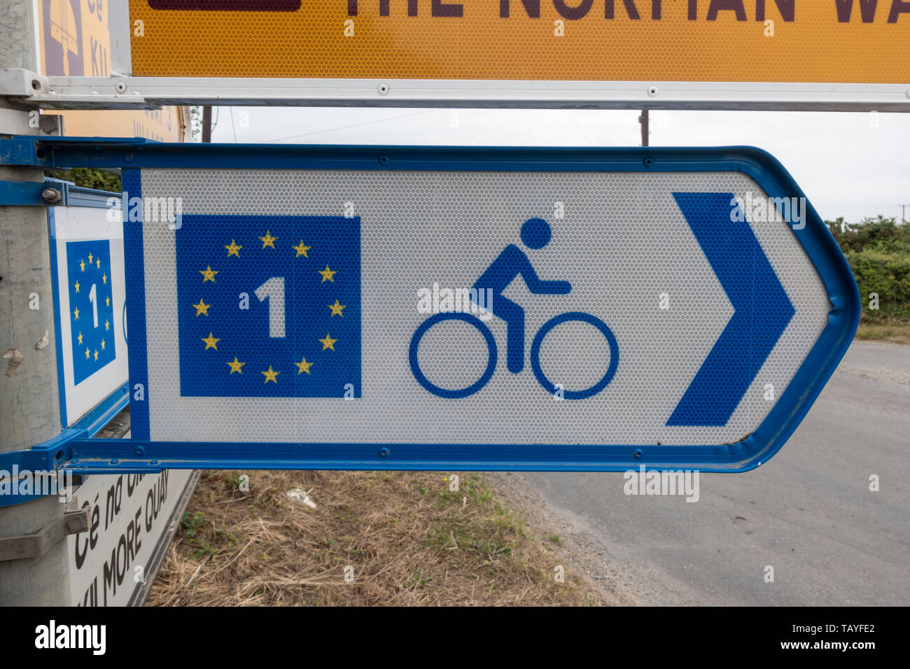 Un cartello stradale che mostra il modo di epoca normanna e EuroVelo 1 ciclo percorso nella Contea di Wexford, Eire. Foto Stock