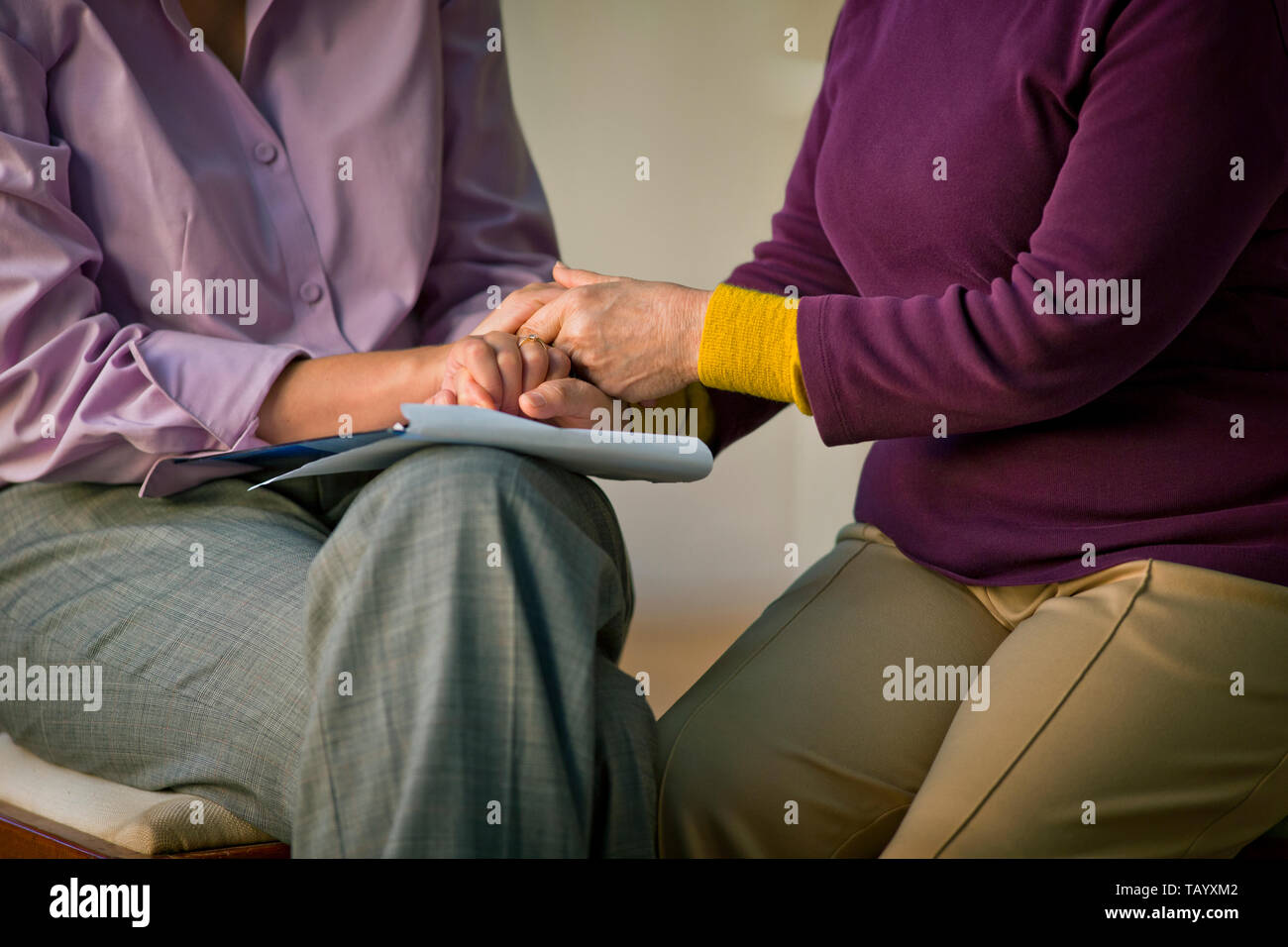 Medico tenendo le mani con il suo paziente. Foto Stock