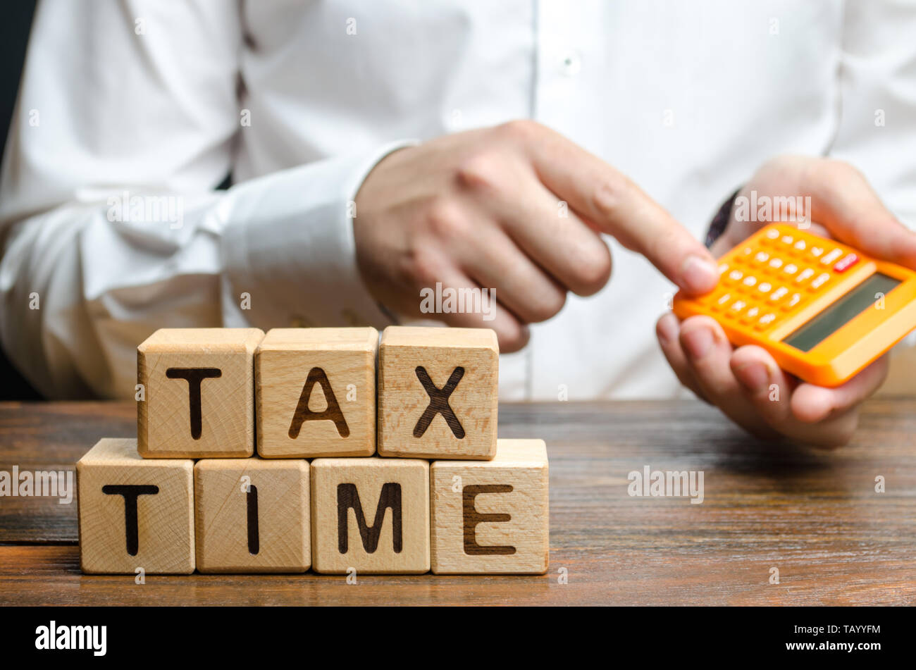 Il ragazzo conta sulla calcolatrice il necessario pagamento tasse. Imposizione fiscale, l'imposta sul reddito. Dichiarando il reddito, lotta contro l'economia sommersa, la digitalizzazione di t Foto Stock