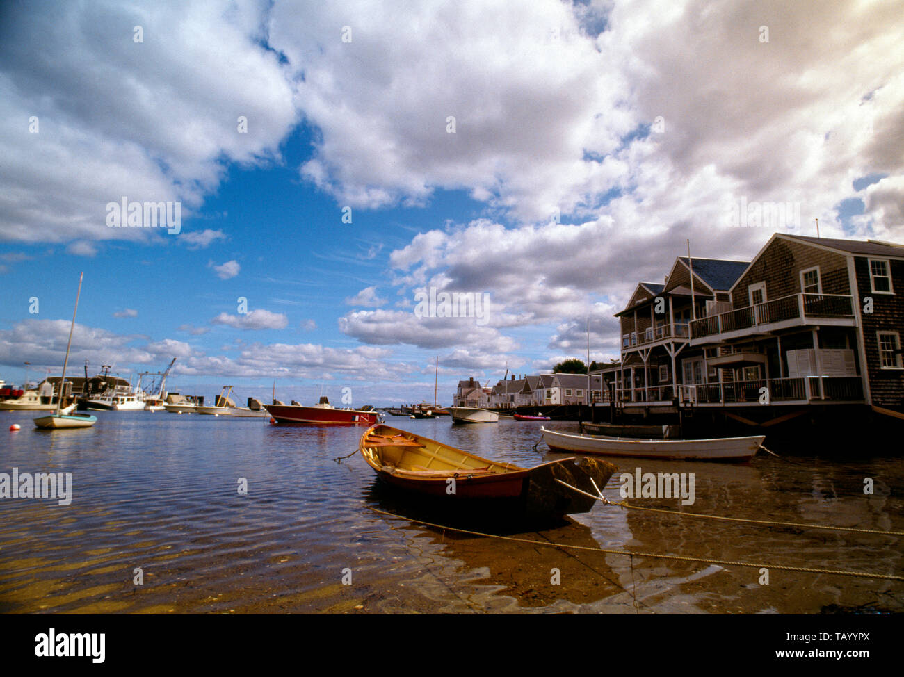 Barche ormeggiate nei bassifondi di una città porto sotto il sole. Foto Stock
