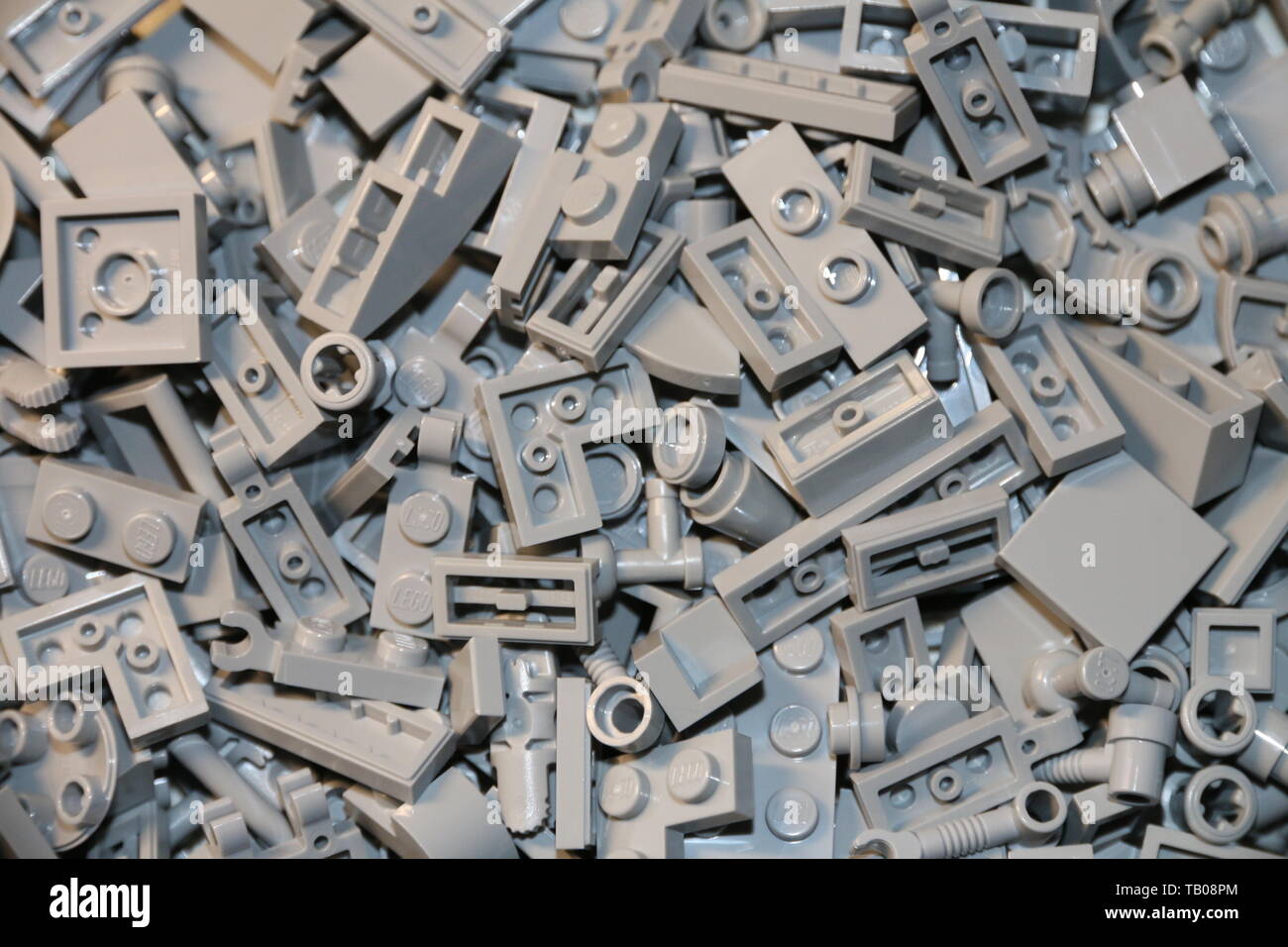 LEGO luce grigio bluastro mattoni e piastrelle, lastre, technic parti insieme su un tavolo. Foto Stock
