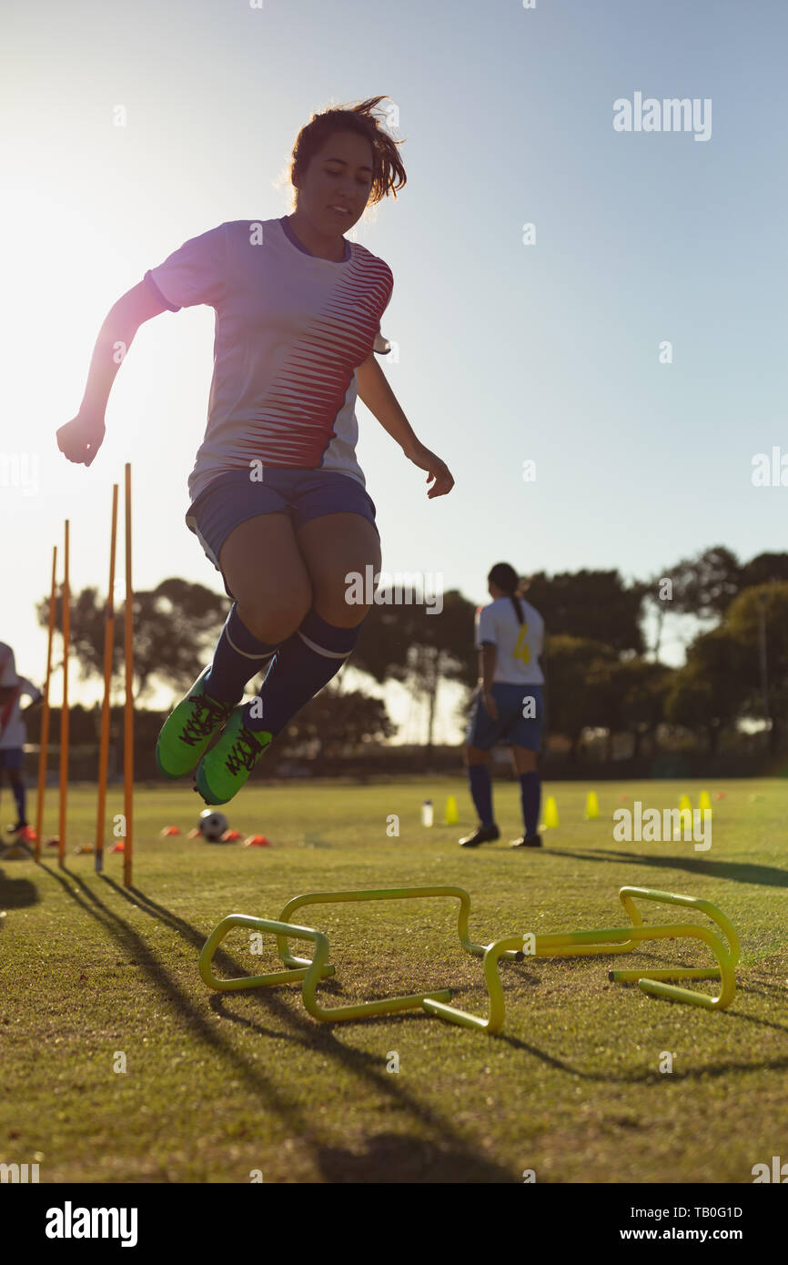 Calcio femminile player saltando ostacoli durante il corso di formazione Foto Stock Calcio femminile player saltando ostacoli durante il corso di formazione Foto Stock