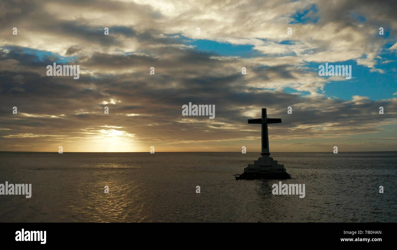 Croce cattolica nel cimitero affondata nel mare al tramonto, antenna fuco. Grandi crucafix segnando il sottomarino sunken cimitero, CAMIGUIN ISLAND Filippine. Foto Stock