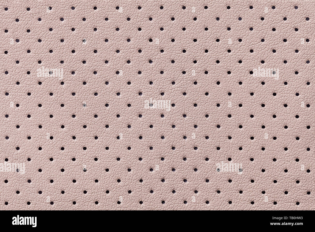Traforato in cuoio beige texture di sfondo, closeup. Luce sfondo marrone da rughe della pelle, struttura del materiale tessile. Foto Stock