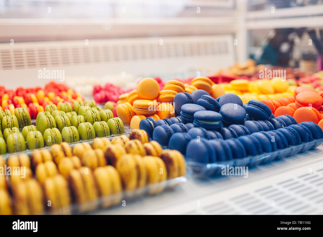Assortimento di amaretti colorati su cafe vetrina. Varietà di sapori macaron. Dolce dolci di mandorla in negozio. Biscotti francesi. Foto Stock