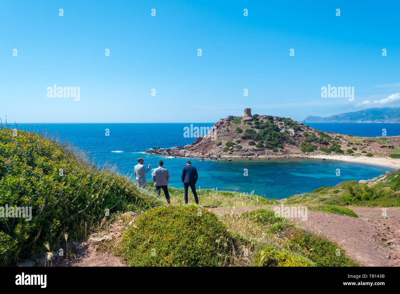Tre imprenditori guardano al mare in Sardegna, nel porticciolo golfo, durante una pausa dal lavoro Foto Stock