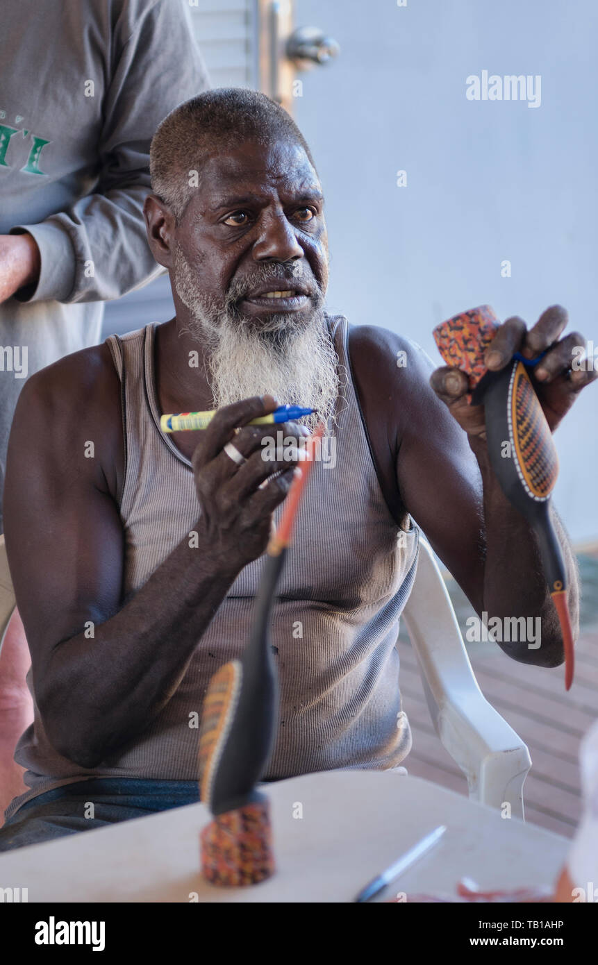 Tiwi Islander artista orgogliosamente la firma di uno dei suoi uccelli Tiwi sculture in legno Foto Stock