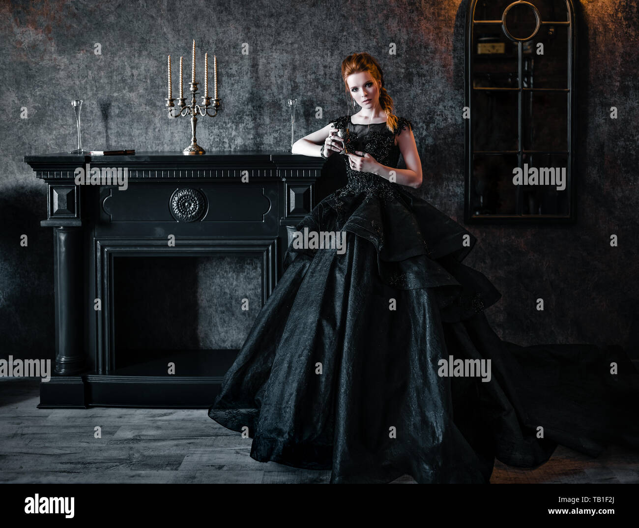 Donna attraente in abito nero nel borgo medievale di interno Foto Stock