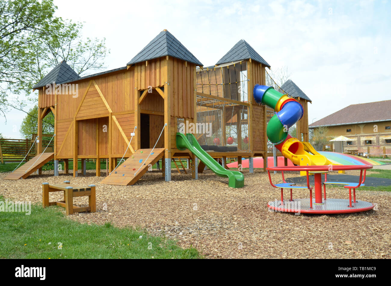 Un parco giochi vuoto castello in legno parco giochi per bambini con scivoli, merry-go-round, rotatoria, e molte altre attrezzature da gioco e attività per piccole e Foto Stock