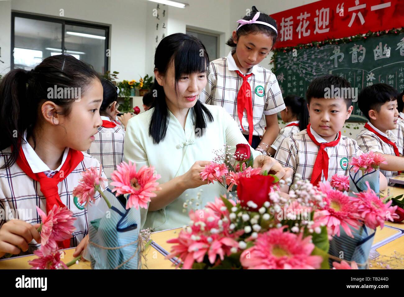 Zaozhuang, la Cina della provincia dello Shandong. 29 Maggio, 2019. Un fiorista (2 L) insegna agli studenti floreale competenze nella celebrazione del prossimo International giornata per i bambini in una scuola primaria nella città di Zaozhuang, est della Cina di Provincia di Shandong, 29 maggio 2019. Credito: Sun Zhongzhe/Xinhua/Alamy Live News Foto Stock