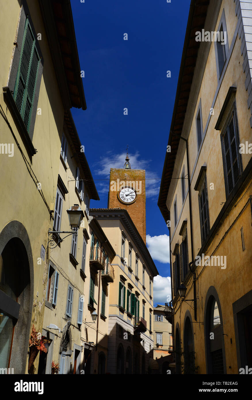 Medievale Torre del Moro (Moro Torre) con il vecchio orologio, uno dei punti di riferimento di Orvieto visto dal centro strada stretta Foto Stock