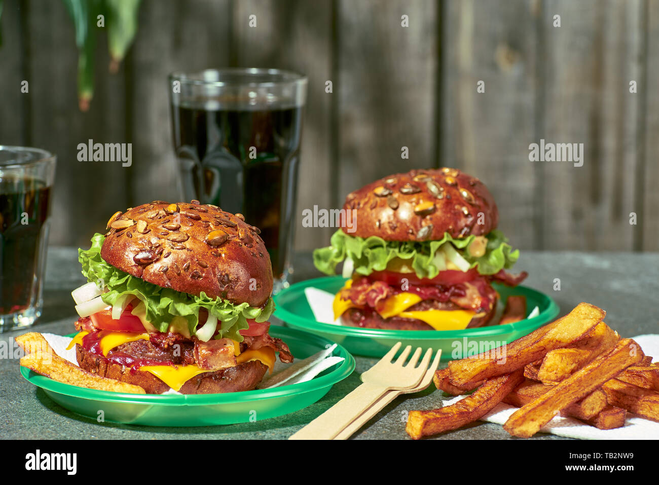 Due hamburger con patatine fritte e bere sul tavolo di pietra Foto Stock