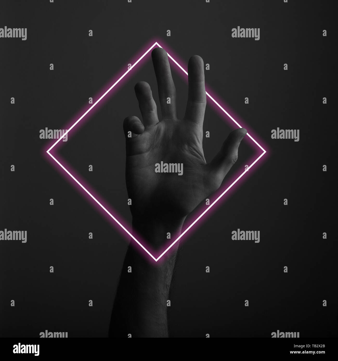 Maschio a mano aperta gesto su uno sfondo scuro con abstract neon di luce soffusa Foto Stock