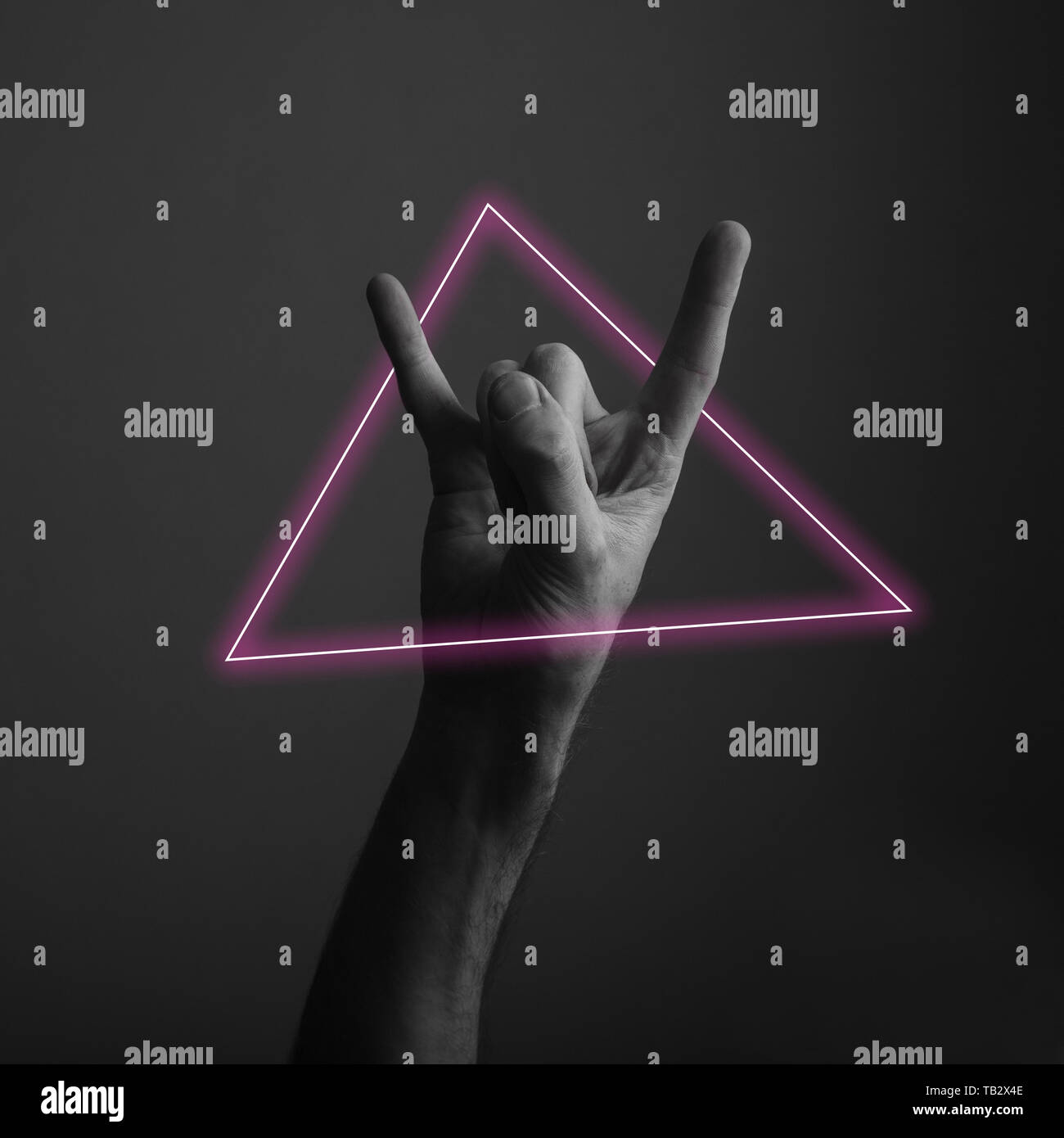 Diavolo maschio avvisatore acustico rock e il gesto a mano con abstract neon di luce soffusa Foto Stock