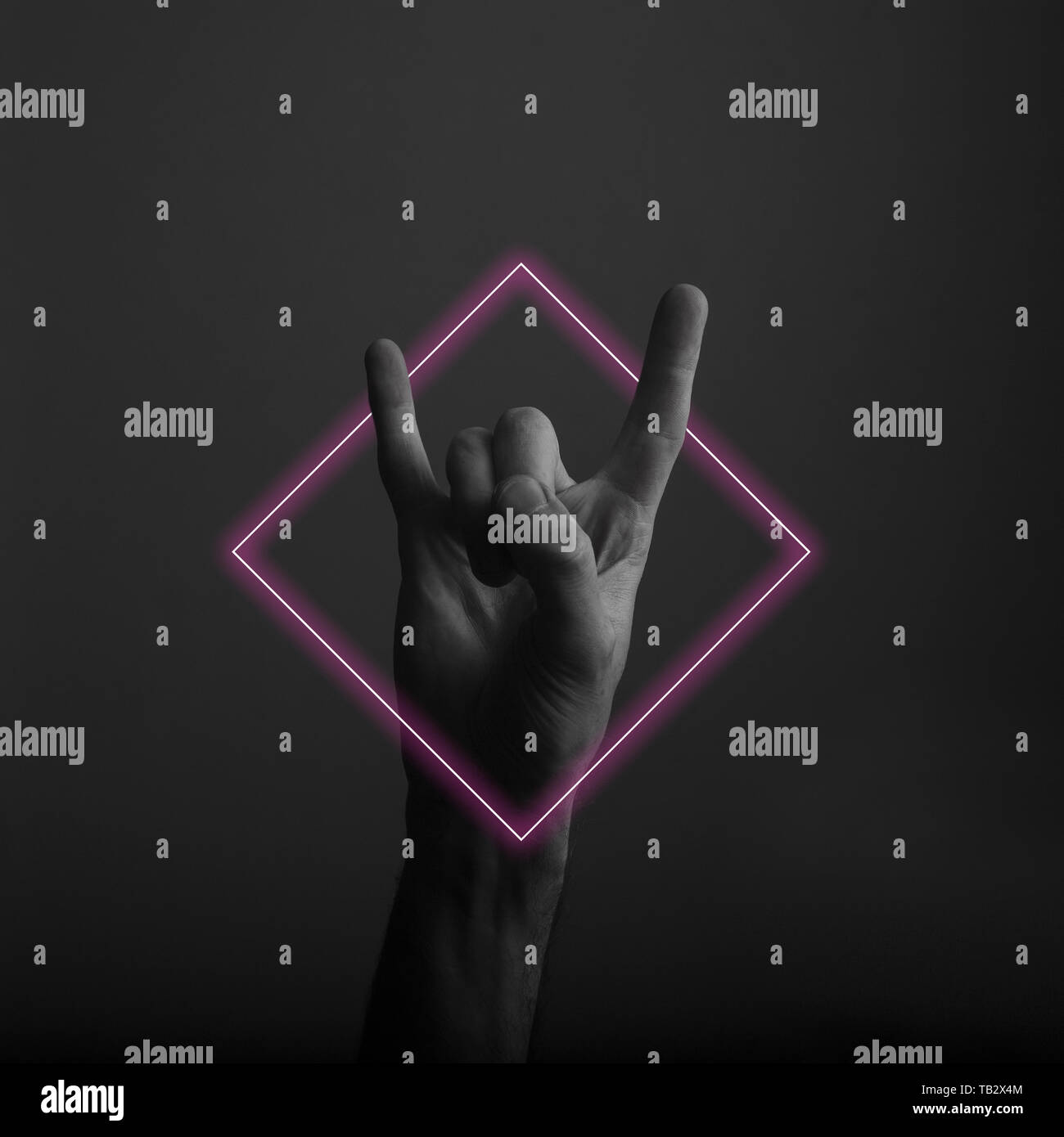 Diavolo maschio avvisatore acustico rock e il gesto a mano con abstract neon di luce soffusa Foto Stock