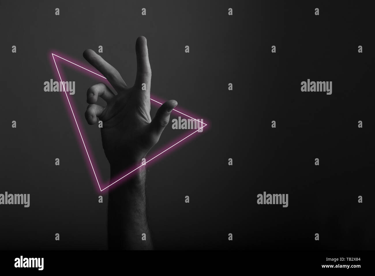 Maschio a mano aperta gesto su uno sfondo scuro con abstract neon di luce soffusa Foto Stock