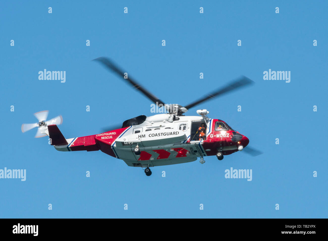 Un Sikorsky S-92una guardia costiera HM elicottero SAR G-MCCZ azionato da Bristol elicotteri volare overhead in Inghilterra, Regno Unito. Foto Stock