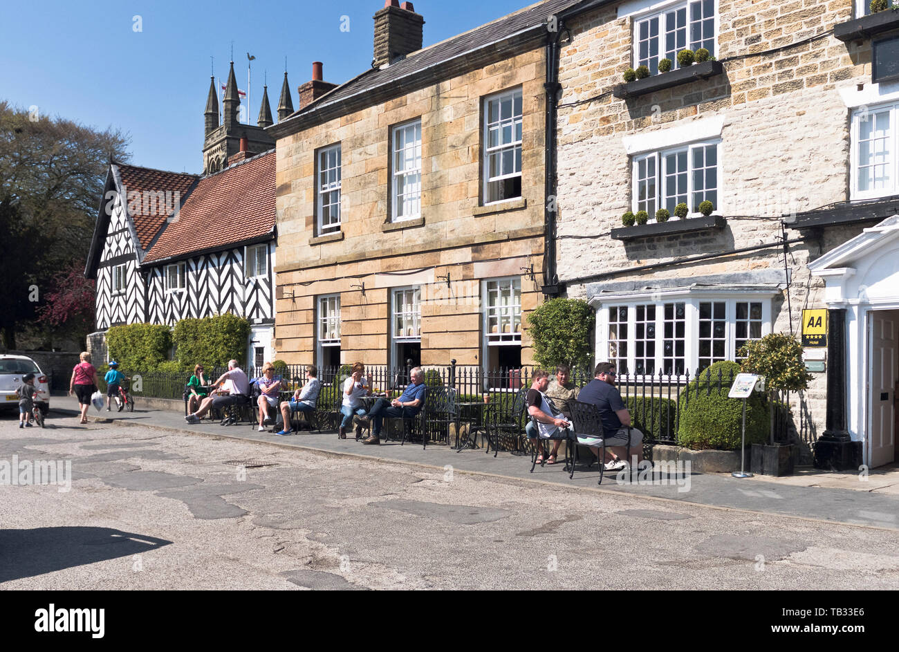 Dh Black Swan Hotel HELMSLEY North Yorkshire persone rilassarsi con drink al di fuori del vecchio inn Foto Stock