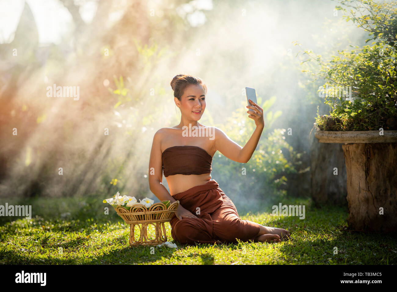 Asia donna sorridente giovani ragazze prendendo selfie ritratto con lo smartphone nel giardino / donna dramma abito stile thai tradizionale costume indossando Foto Stock