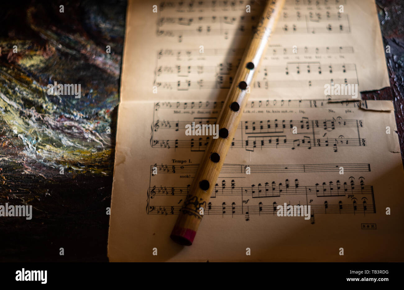 Flauto di legno sul vecchio foglio di musica e colorful canvas background. Close up. Foto Stock