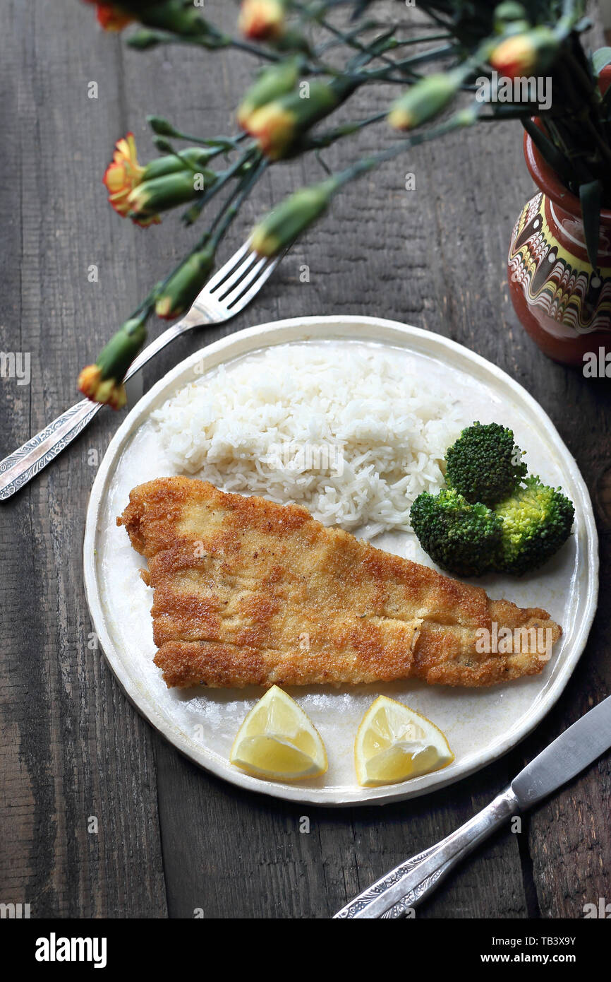 Pesci di mollica di pane fritti in olio con il riso e i broccoli. Foto Stock