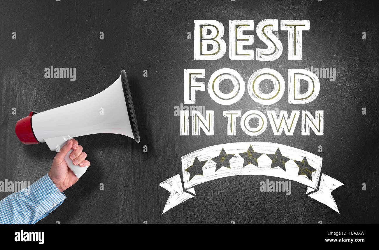 Il cibo migliore in città scritta sulla lavagna e mano azienda megafono Foto Stock