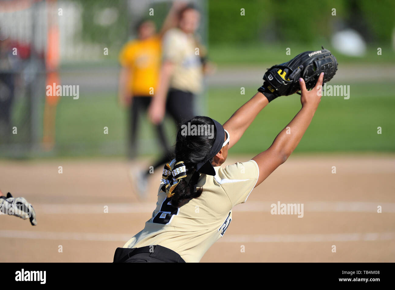 Primo baseman stretching per la cattura di un tiro da un infielder al ritiro la pastella/runner alla prima base. Stati Uniti d'America. Foto Stock