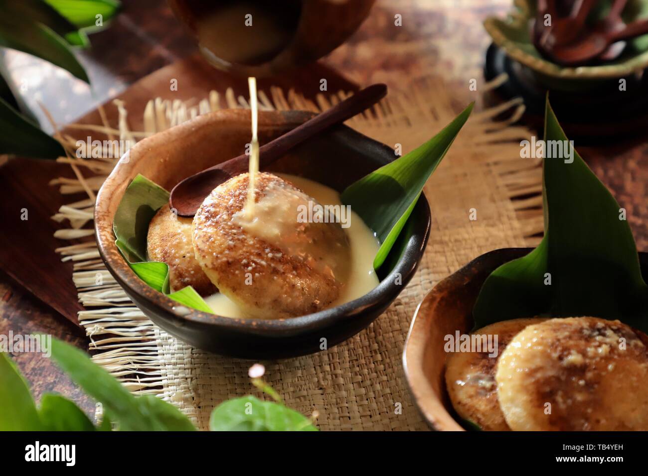 Serabi Kocor. Javanese tradizionale pancake con latte di cocco salsa dolcificato con Brown Sugar Palm. Foto Stock